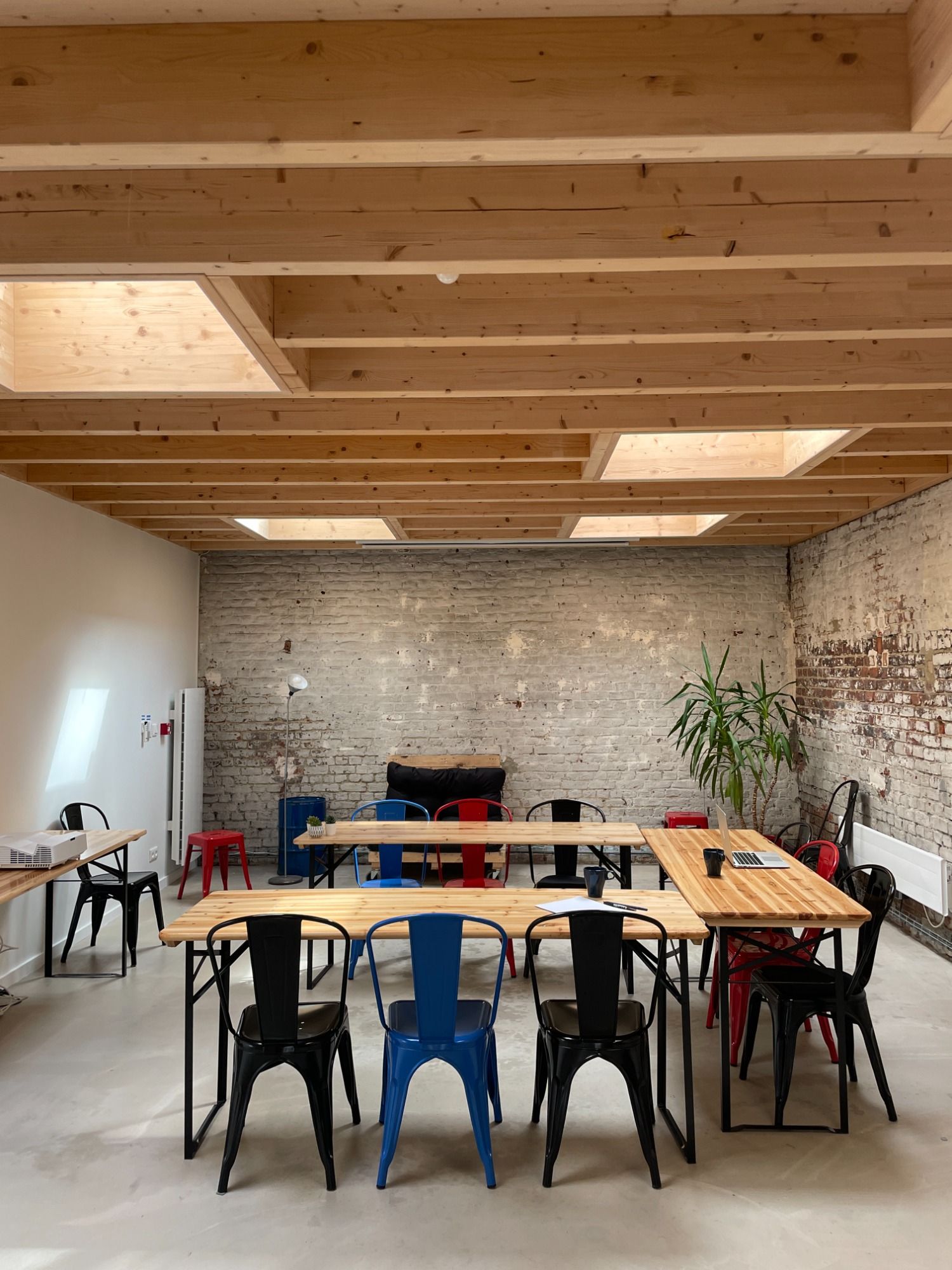La salle Garuma : briques blanchies, charpente bois et tables en bois clair